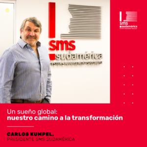 Señor parado frente al logo de SMS Sudamérica