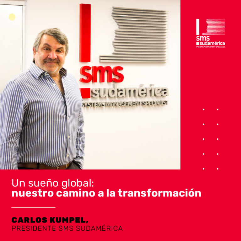 Señor parado frente al logo de SMS Sudamérica